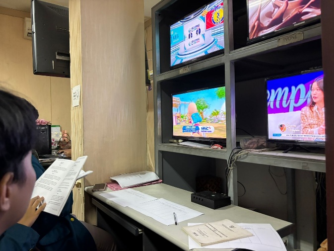 A person sitting at a desk with a paper and a few monitors AI-generated content may be incorrect.